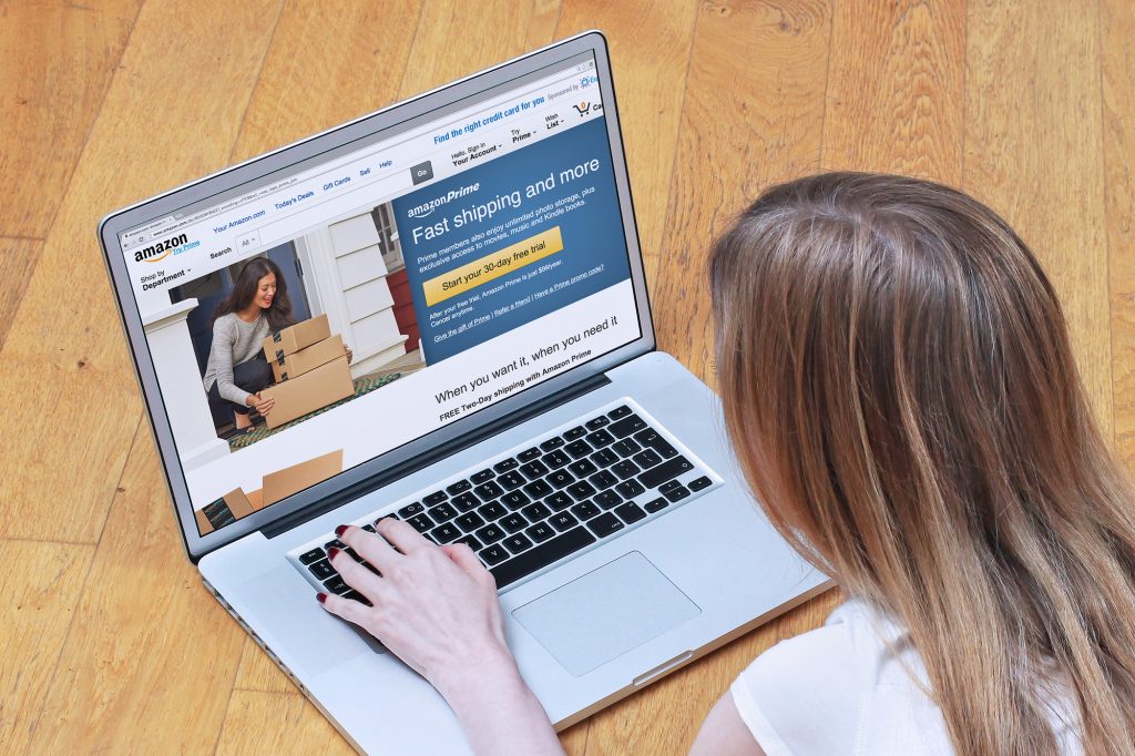 London, UK - February 06, 2015: Young woman signing up for Amazon Prime on online shopping site. Amazon Prime is paid service that gives Amazon shoppers free delivery and access to Prime Instant Video