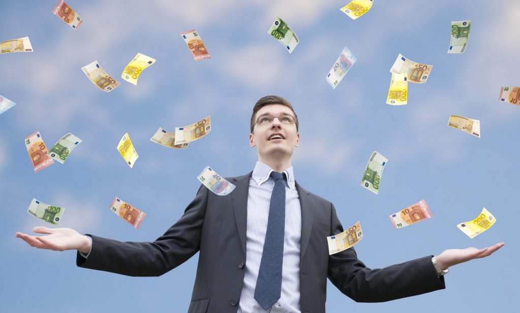 Happy businessman standing in the rain of euro money. Euro are falling from the sky