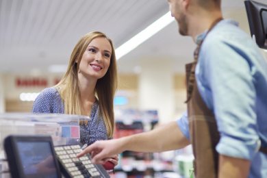 Woman next to cash register talking with sales clerk