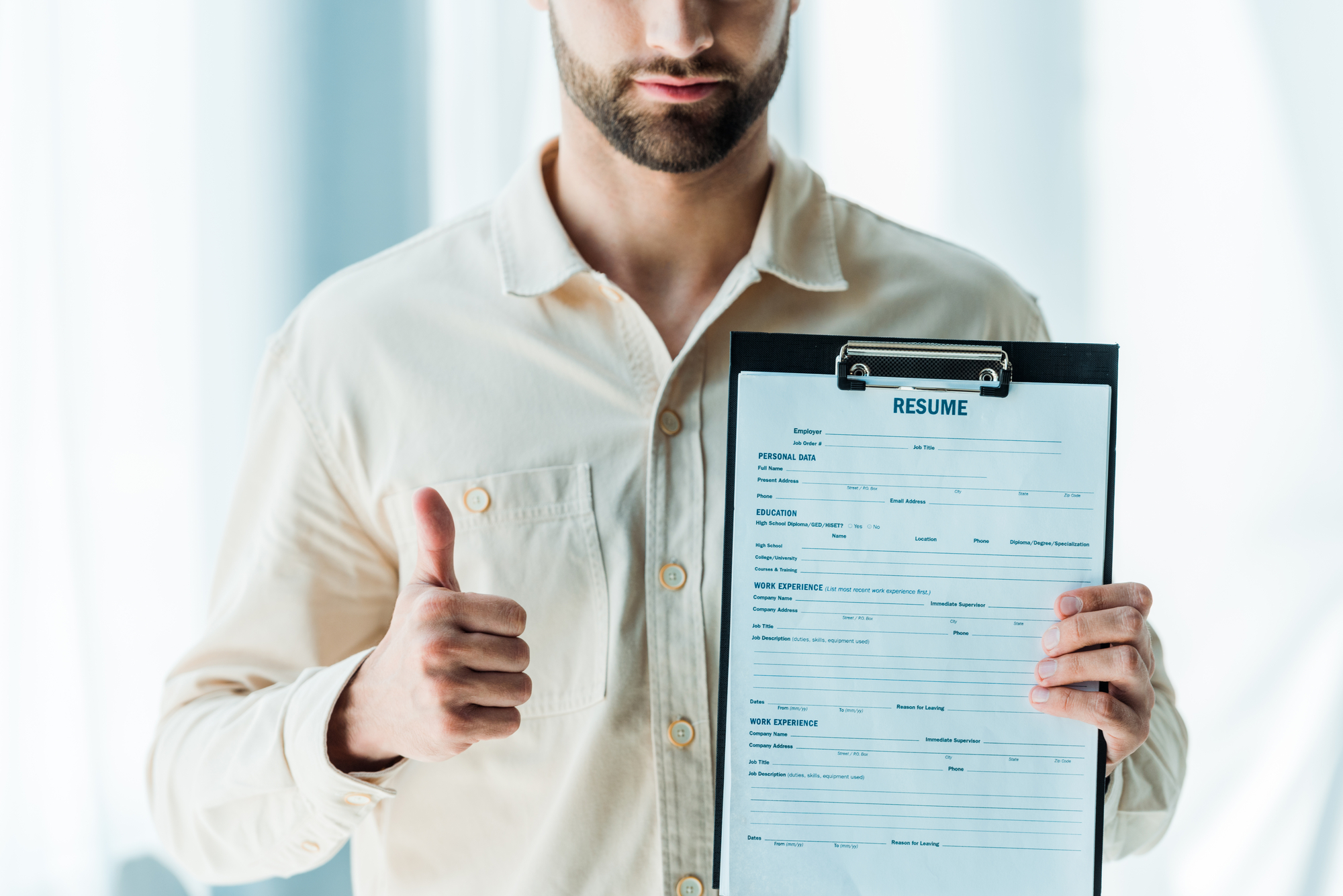 man holds a well-written resume in his hands