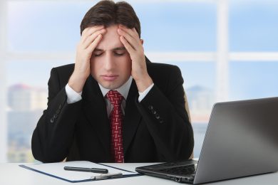 young businessman under stress, fatigue and headache, he kept his hands behind his head