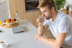 Чоловік п'є воду