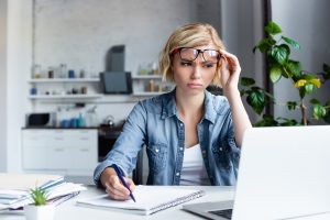 засмучена дівчина працює за ноутбуком