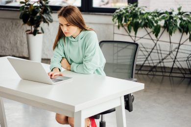 дівчина у світлому одязі працює за ноутбуком