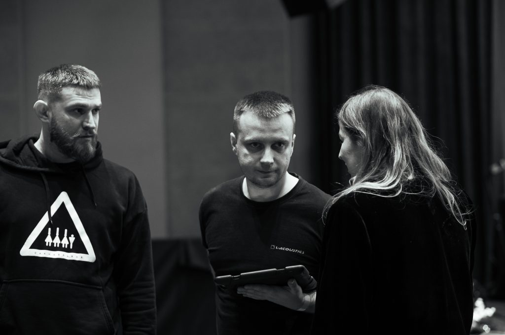 Чорно-біле фото з двома чоловіками та жінкою, що розмовляють