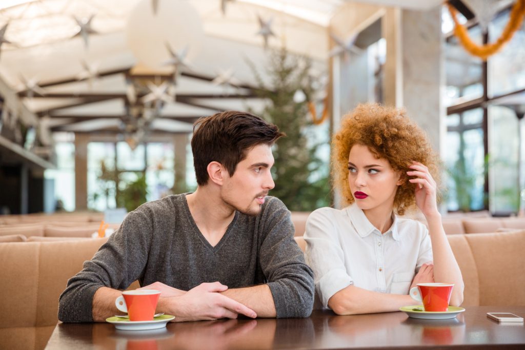 Чоловік та жінка сидять в кафе з кавою