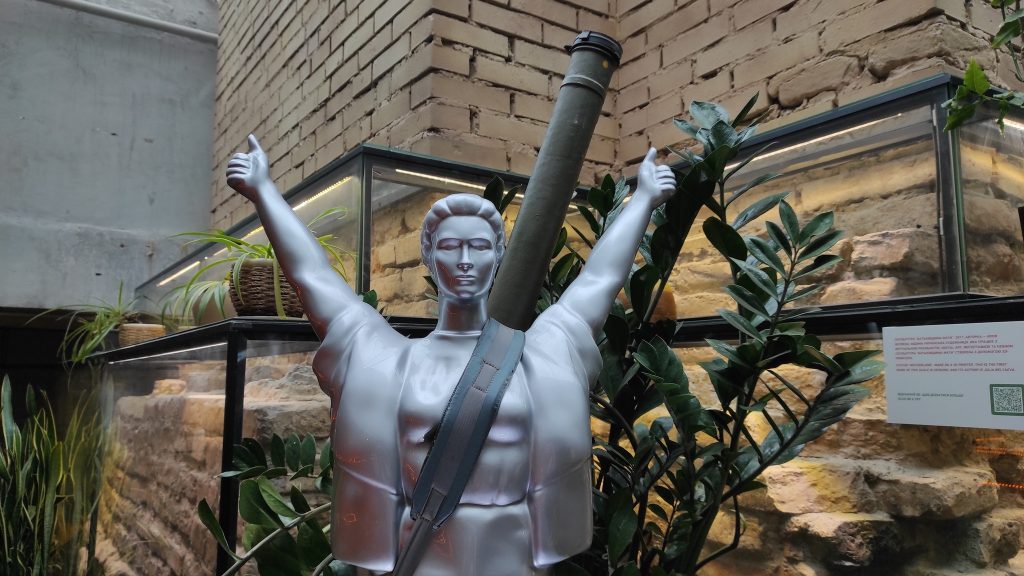 Скульптура жінки зі зброєю