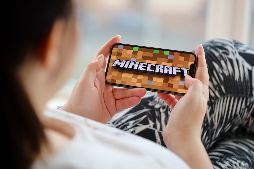 Дівчина грає на телефоні в Minecraft