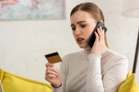 жінка засмучена, тримає картку