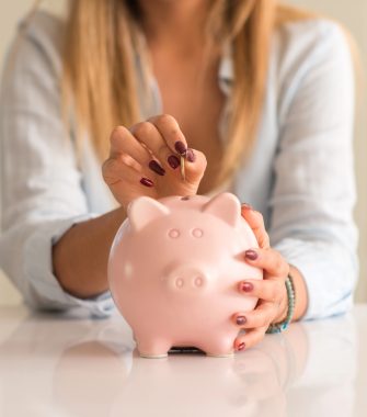 жінка кидає монету в скарбничку