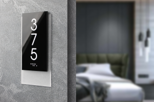 Готельна табличка з номером кімнати на стіні біля входу