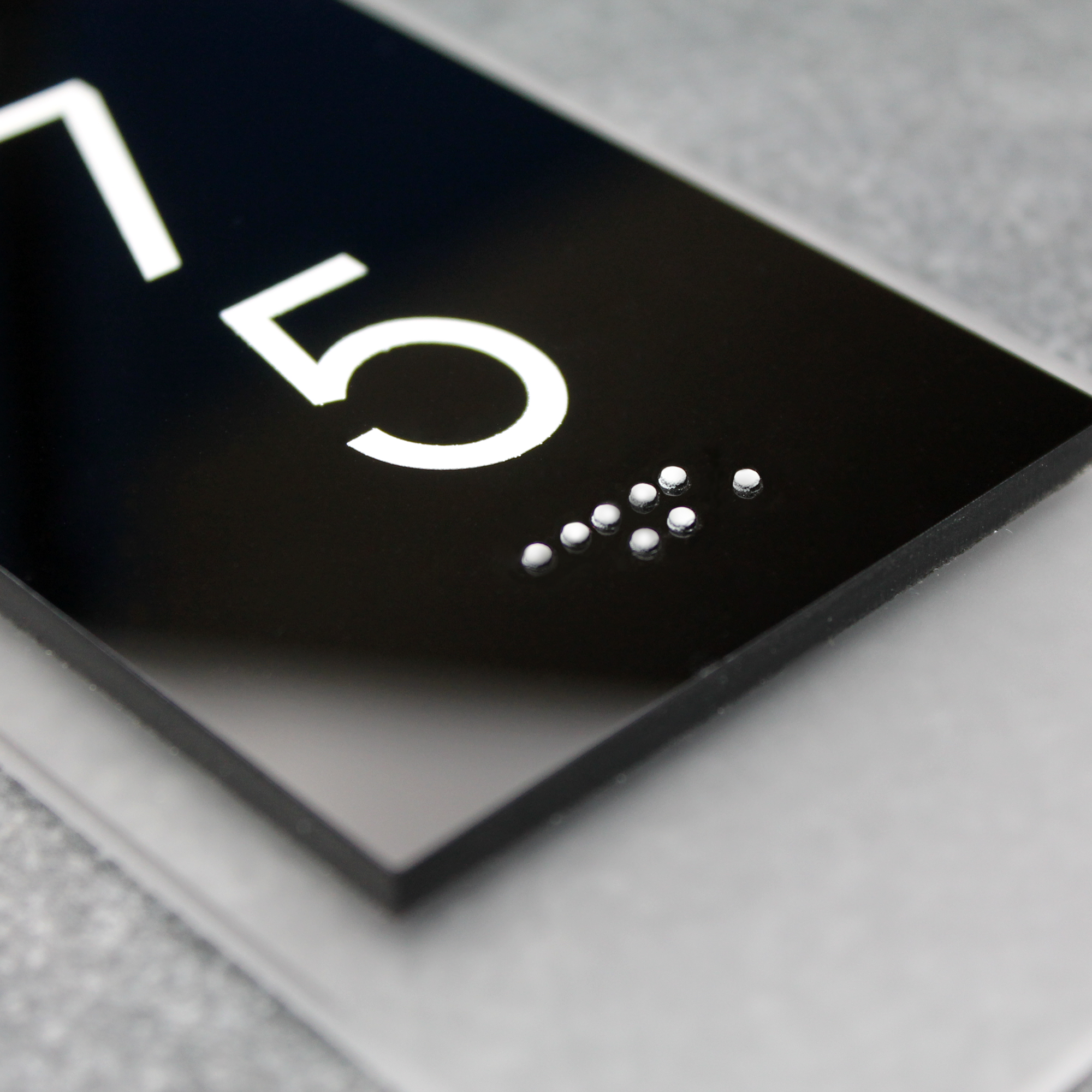 Крупний план готельної таблички з номером і тактильним шрифтом Брайля