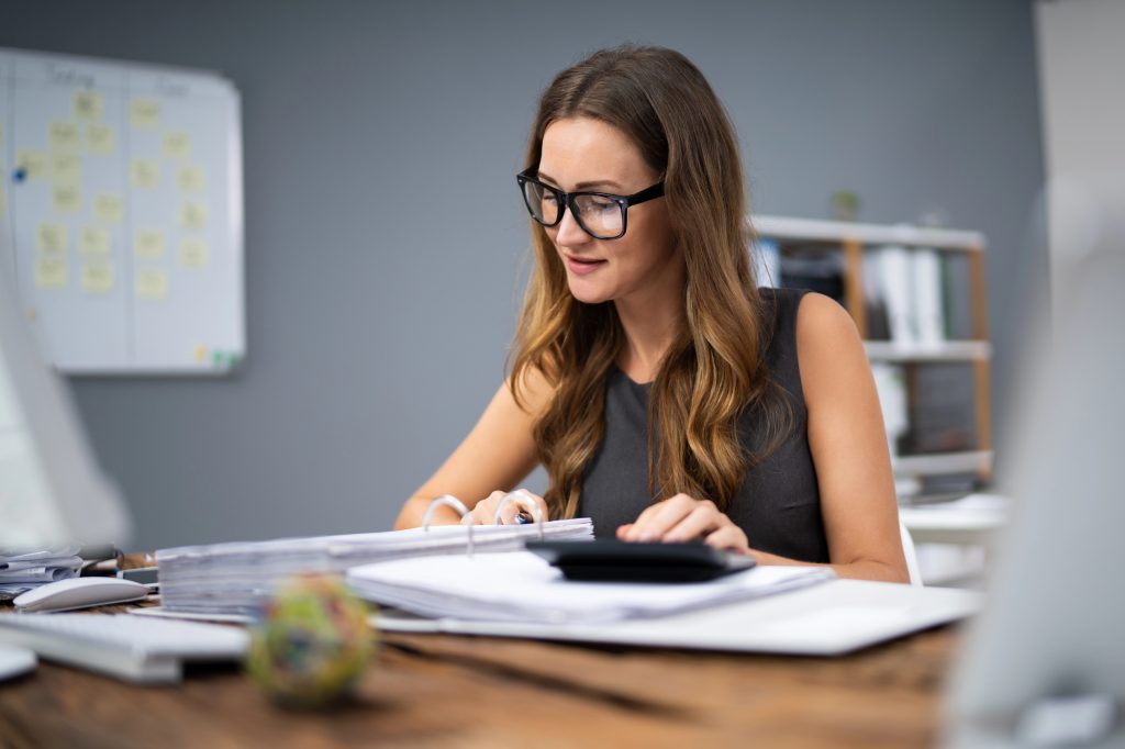 бухгалтерка рахує, дивиться документи