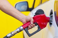 людина заправляє білу машину