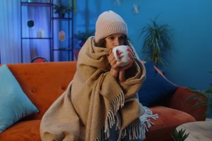 Тепло одягнена дівчина на дивані в приміщенні