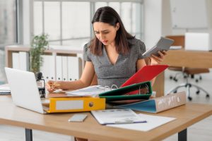 бухгалтер, дівчина в офісі розбирається в документах