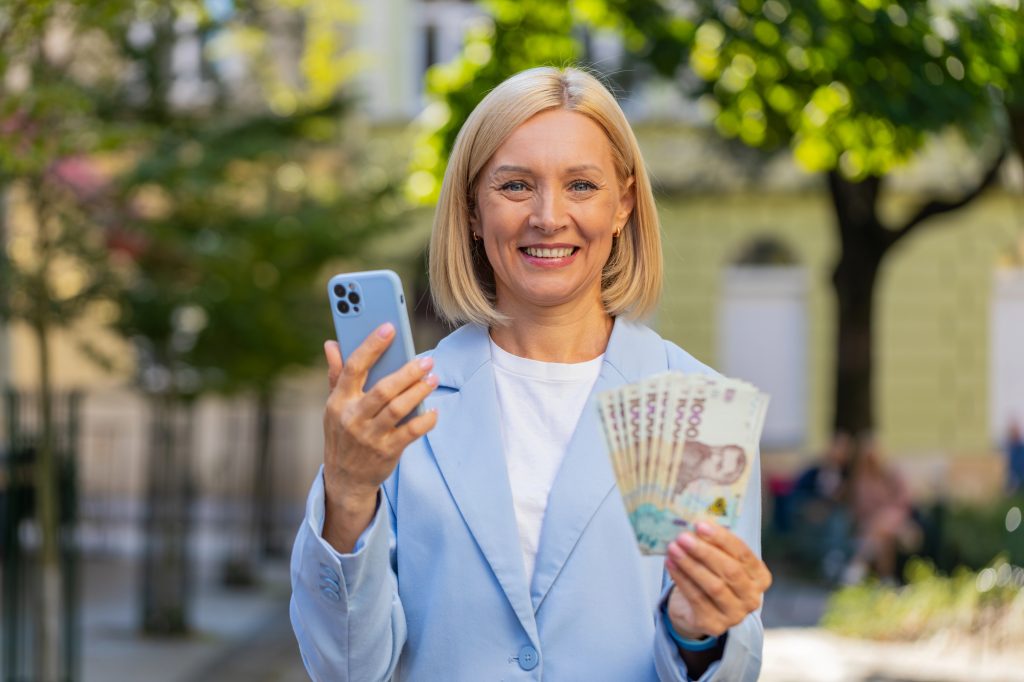 Жінка, гривні, смартфон