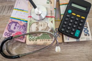 гроші, стетоскоп, калькулятор