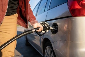 чоловік заправляє темне авто