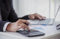 чоловік рахує на калькуляторі, підприємець
