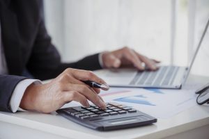 чоловік рахує на калькуляторі, підприємець