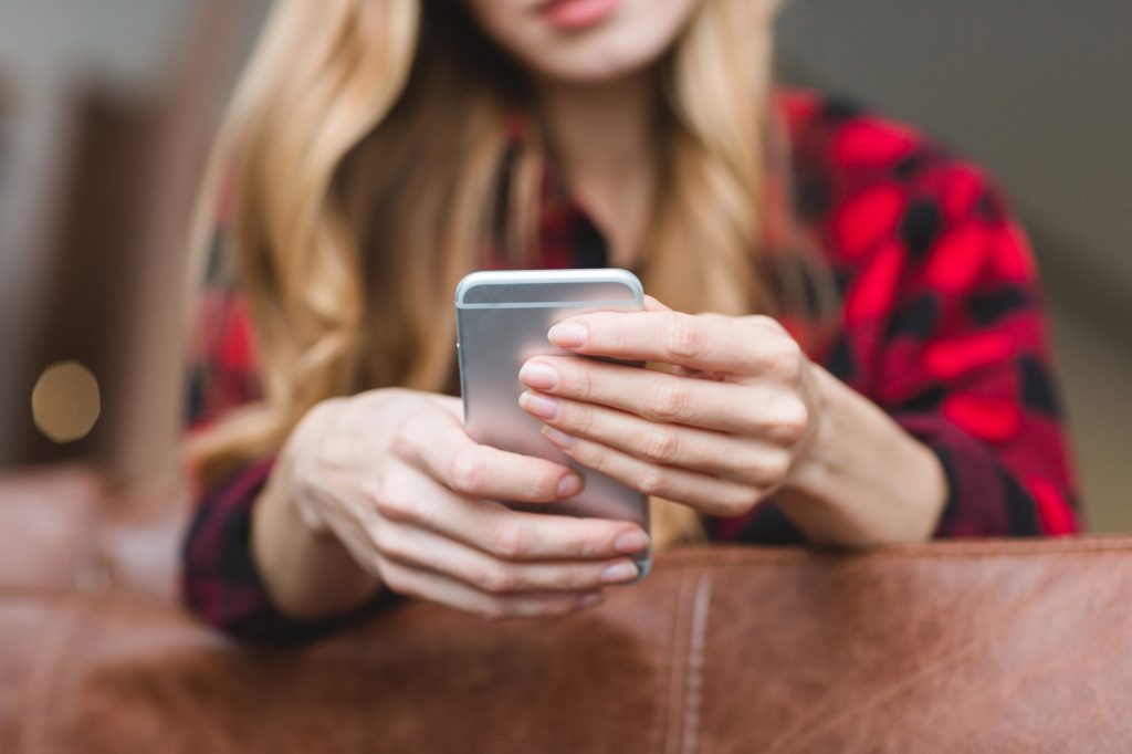 дівчина тримає телефон
